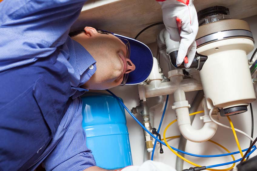 plumber fixing garbage disposal