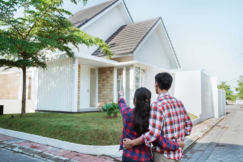 a person or couple posing in front of a house