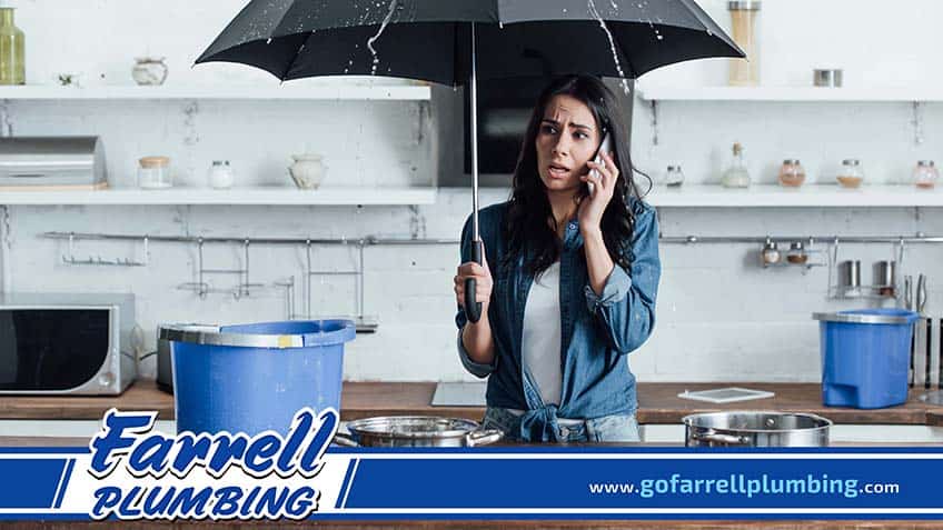 Woman Calling a Plumber Due to a Leaking Ceiling in the Kitchen