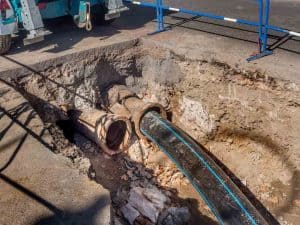 sewer pipe being inserted into a broken cast iron pipe