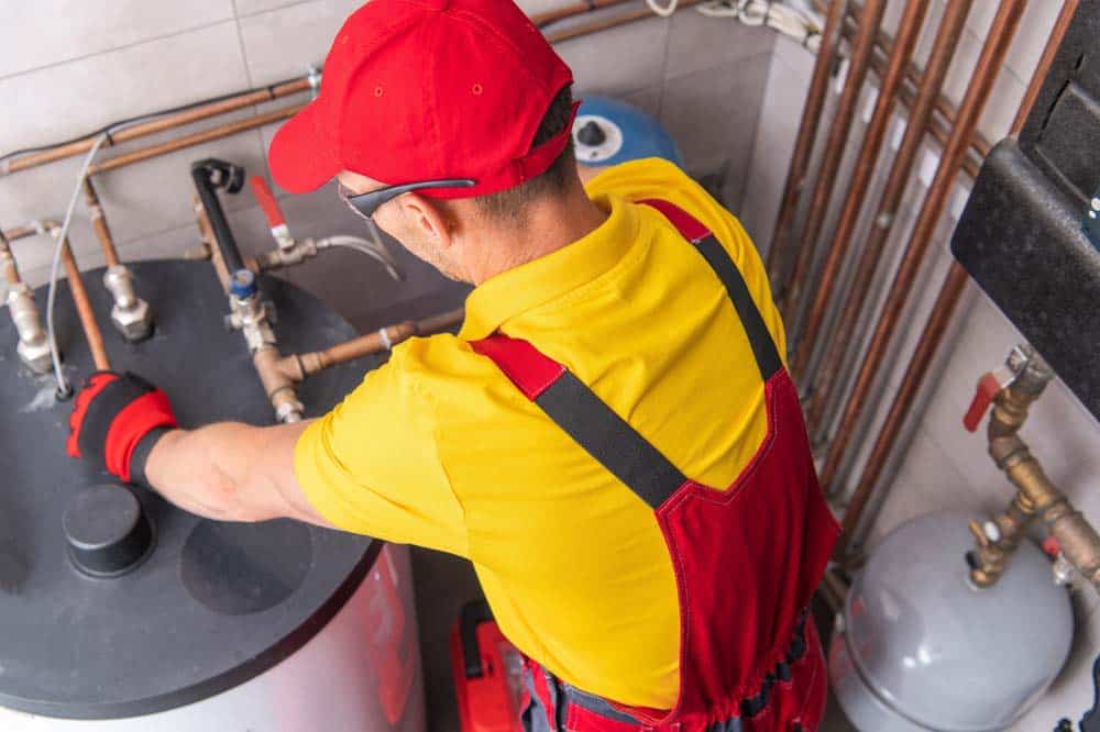 plumber inspecting a water heater tank