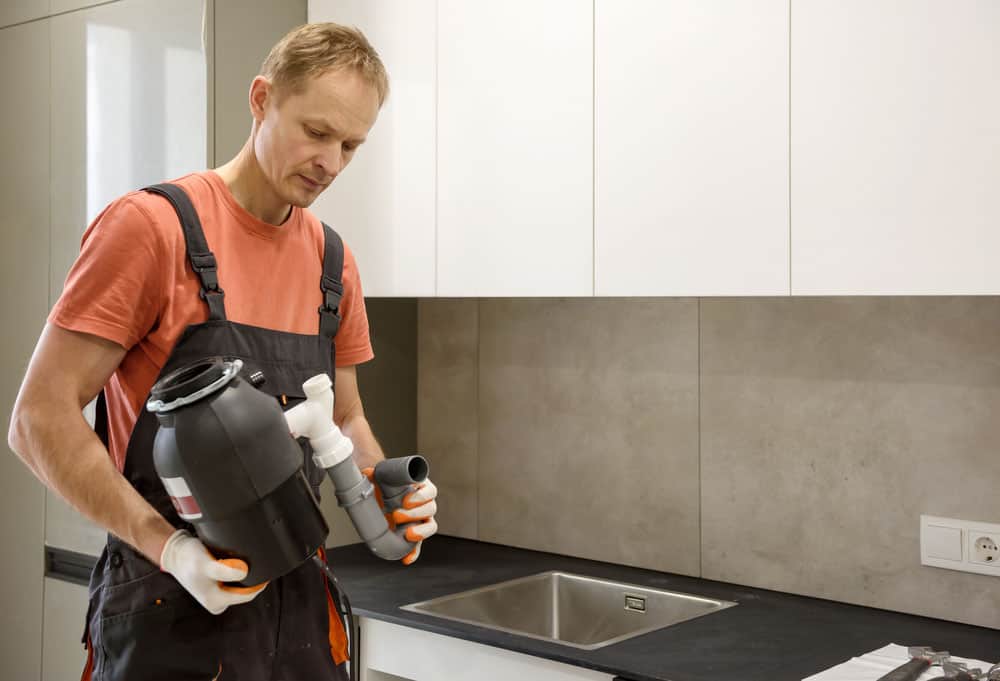 homeowner inspecting a garbage disposal