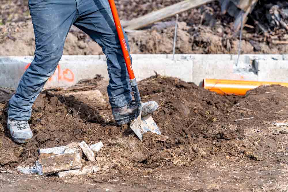 technicians repairing a sewer line (through excavation)