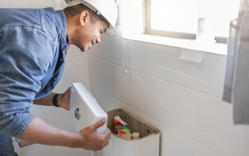 plumber checking a toilet tank