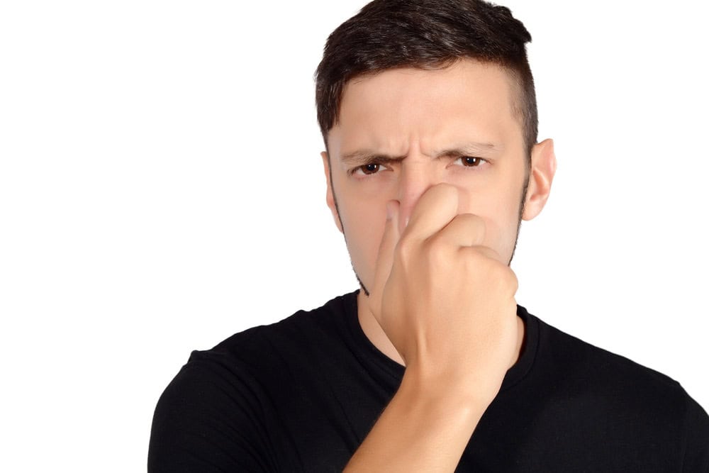 person holding their nose